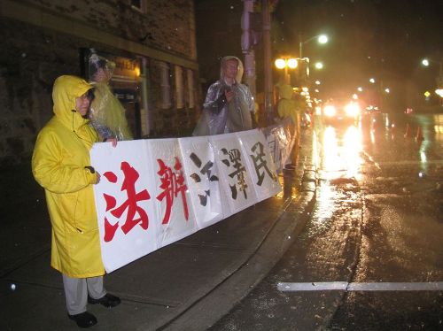 '图5:加拿大博物馆前大雨中在夜晚里等待李克强一行国宴结束的法轮功学员'