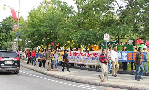 图6:总督府门前,大陆旅游团经过法轮功的打横幅队伍,有人现场做了三退。