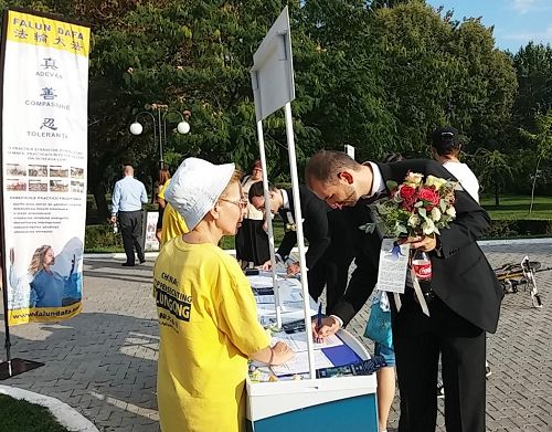 罗马尼亚特尔戈维什泰市(Targoviste) 的Chindia公园里,人们签名支持法轮功反迫害
