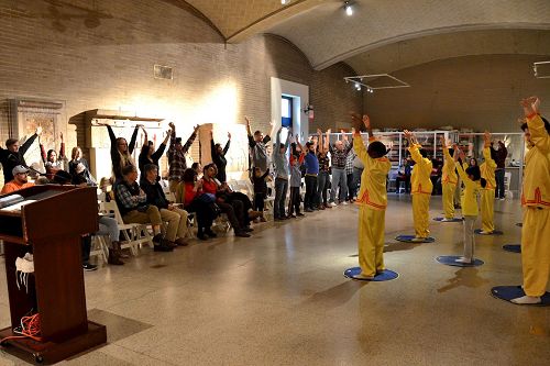 '图2:民众跟着法轮功学员学炼功法动作。'