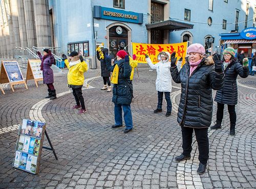 '图3:在斯德哥尔摩繁华的闹市区(Hötorget)法轮功学员举办弘法讲真相活动,法轮功学员向民众演示功法,'