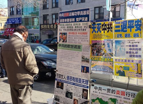 '图1~3:大年初二,法轮功学员们在热闹的布碌仑街上向民众传递真相,很多华人民众驻足阅读真相展板'
