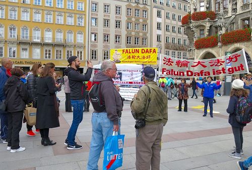 '图1:法轮功学员在玛琳广场展示功法及揭露中共活摘器官的横幅吸引了民众观看。'