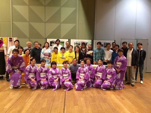 '图1:稻泽市民会馆的六鹿(Mr. Mutsuga)馆长与部份参加本次活动的团体人员法轮功展位前合影留念。'
