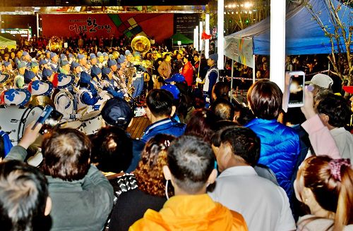 '图5:天国乐团和法轮功功法演示队面向审查团和观众进行表演,观众纷纷拿出手机拍照、录像。'