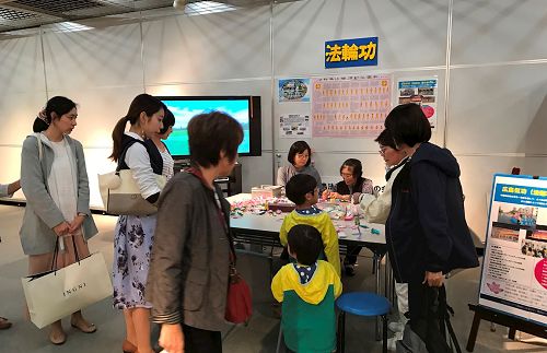 '图3:前来展位了解法轮功的民众'