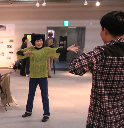 '图5:这位绿衣女士炼了一会儿功后说,身体很热'