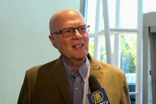 '图12:华府一家理疗机构CEO丹尼斯(Bill Dennis)和太太聆听了神韵交响乐团的演出后,感受到身心被治愈,所有忧虑都消失无踪。'