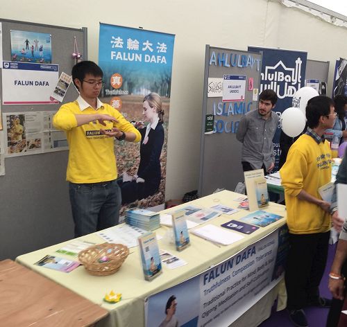 '图1:英国青年学员在英国金斯顿大学(Kingston university)大型室内年度学生社团迎新会上弘法'