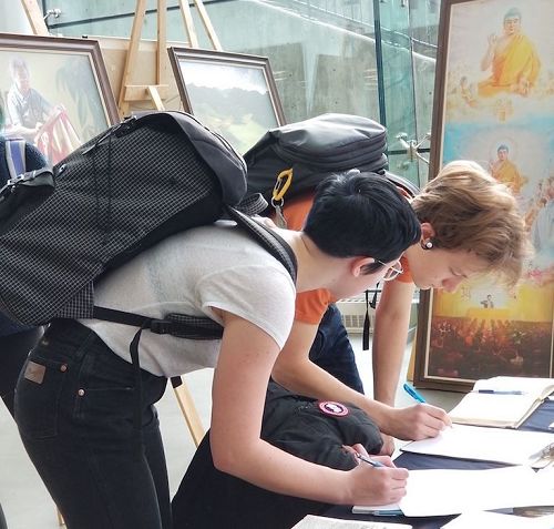 图3:观看画展的学生主动签名呼吁加国总统帮助营救法轮功学员。