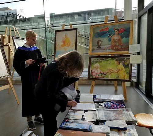 图4:观看画展的阿伯达大学毕业生及家长主动签名呼吁加国总统帮助营救法轮功学员。