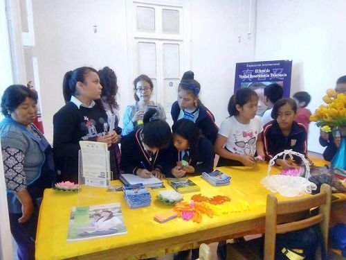 '图7:Colegio Sagrado Corazon学生观看画展后争相在留言簿上留言。'