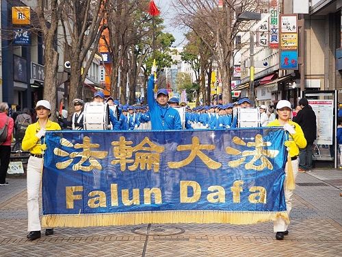 '图1:三月十九日,来自日本各地的法轮功学员齐聚横滨举行了游行活动,图为游行队伍经过横滨中心部的关内的场景'