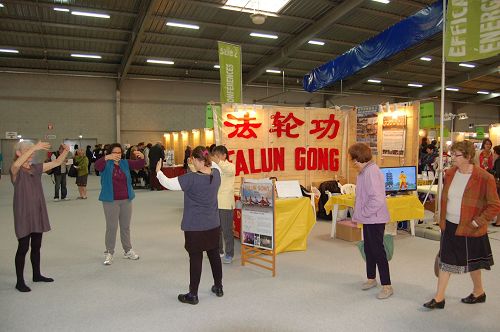 '图2:听完介绍后,许多观众马上表示浓厚兴趣,当场认真学炼五套功法。'
