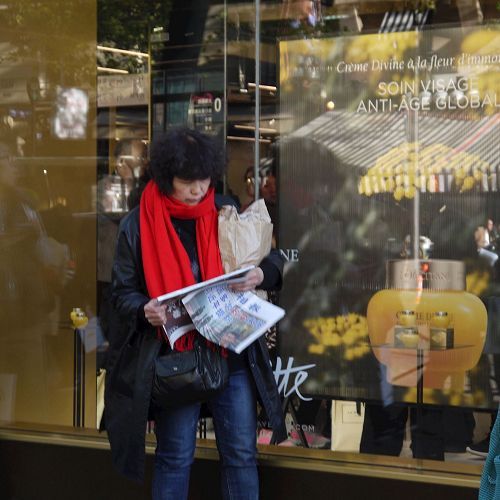 '图1~2:来法国旅游的大陆游客认真阅读真相报'