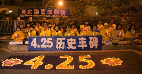 图1-2:四月二十三日傍晚,美国首都华盛顿地区的部分法轮功学员在中共大使馆前点燃烛光,纪念“四·二五”和平上访十八周年。
