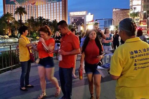 '图1~4:二零一七年四月二十三日,拉斯维加斯的法轮功学员来到赌场大道的“火山秀”景点,向中西方游客讲述法轮功的真相。'