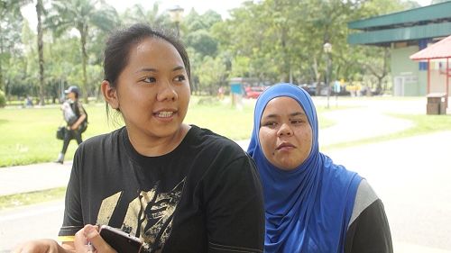 '图12:马来民众Ika(左)和Zulaihah(右)主动向学员要求签名举报迫害元凶江泽民,帮助制止迫害。'