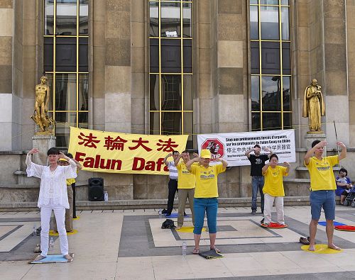 图1 :二零一七年五月二十八日下午,部分巴黎法轮功学员来到艾菲尔铁塔下的人权广场,向各国游客及巴黎民众传播法轮功的真相。图为法轮功学员正在演示功法。