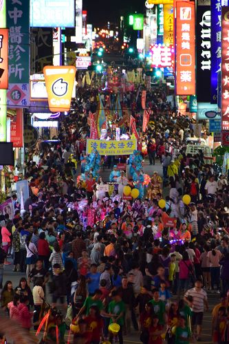 图4:在热闹的踩街人群中,腰鼓队与“法轮大法好”旗帜构成了一幅鲜明美好的画面。