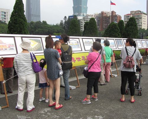 '图4~5:法轮功正法之路图片展吸引游客驻足观看。'