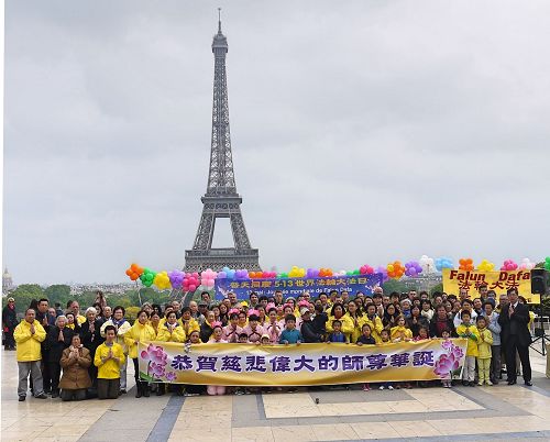 '图1:法国部份法轮功学员聚集在艾菲尔铁塔下的人权广场,庆祝法轮大法洪传世界二十五周年,同时向法轮功创始人李洪志先生恭祝生日快乐。'