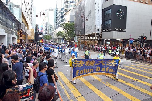 '图6~11:法轮功学员游行庆祝“世界法轮大法日”,及“法轮大法弘传世界二十五周年”纪念,吸引香港市民及中西游客驻足关注及拍照。'