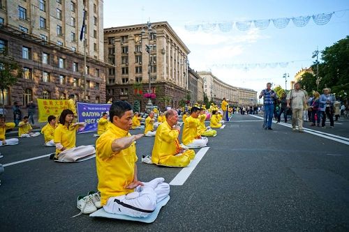 '图2~3:法轮功学员集体炼功的祥和场面,令过往行人瞩目。'