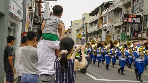 '图3:很多市民拿手机争相对着行进中的天国乐团拍照。'