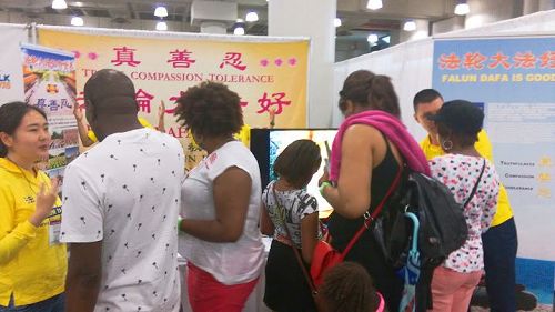 '图1~4:二零一七年六月十日、十一日,法轮功学员参加了第六届绿色节博览会,向民众介绍法轮功。许多民众驻足了解。'