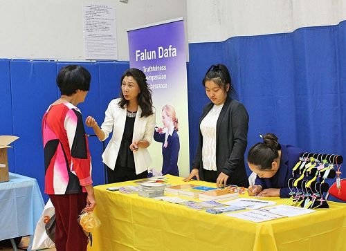 '图1~2:不少民众前来法轮功展位,与学员攀谈,了解法轮功的真相。'
