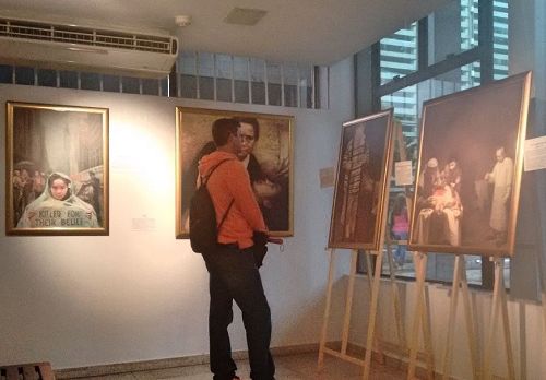 '图5:Marlus正在认真观看“真善忍美展”的画作。他说:“迫害正信者不配做人!”'