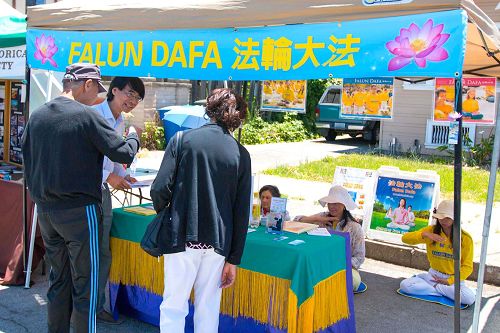'图1:民众在法轮功真相摊位前了解真相'