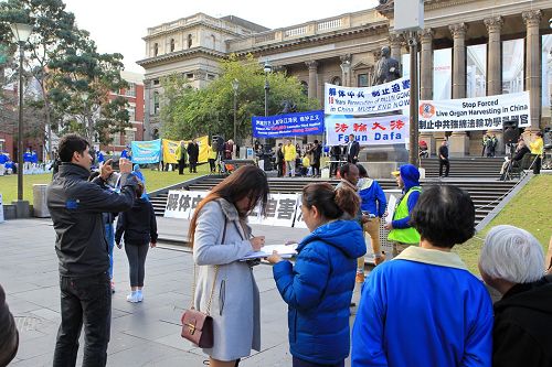 图7-9:人们驻足集会现场,签名支持法轮功反迫害