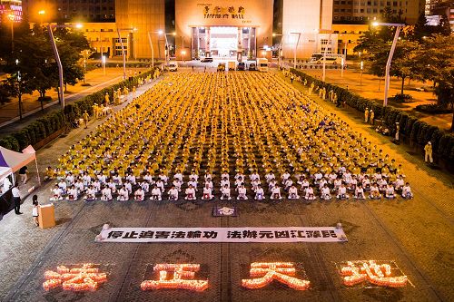'图1:法轮功学员在台北市政府广场前举办反迫害18周年烛光悼念活动。'