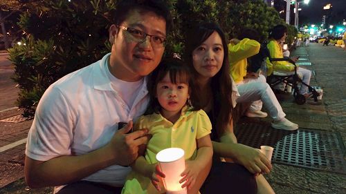 '图10:曾奎皓(左)带着妻子(右)、女儿(中)一同参加烛光悼念会。'