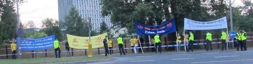 '图1:在华沙军用机场口,法轮功学员打出抗议横幅'