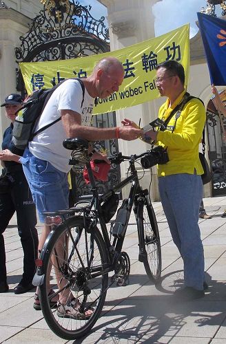 '图8:在华沙总统府外,法轮功学员为过往行人讲真相'