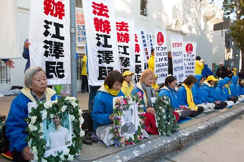 '图10:韩女士手捧被中共迫害致死的儿子叶浩的遗照,抗议中共的迫害'