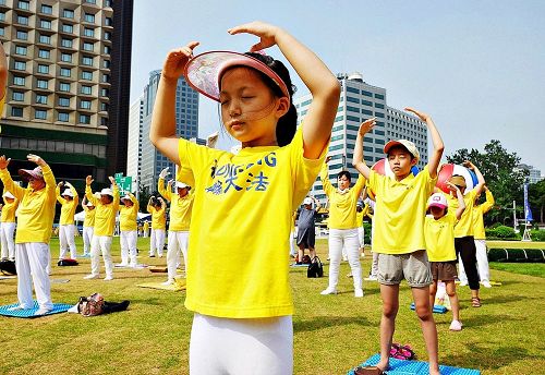 '图1~3:二零一七年七月二十日,韩国法轮功学员在首尔广场举行“七二零”反迫害十八周年集会活动。图为集会之前集体炼功场面。'