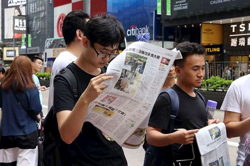 '图15~16:游客接获《明慧周报》等真相资料,欢天喜地的与游行队伍合照,有的迫不及待的阅读起来。'
