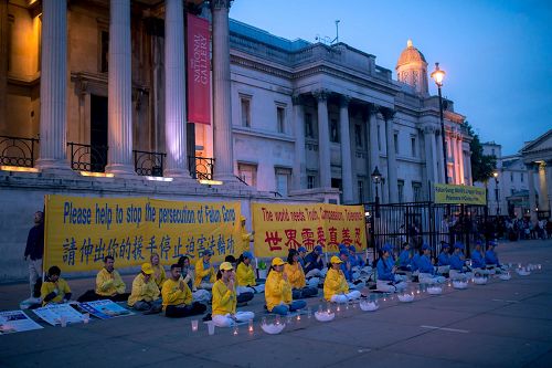 '图1~2:二零一七年七月二十三日,英国法轮功学员在伦敦特拉法加广场(又名鸽子广场)烛光守夜,呼吁世人携手制止中共迫害法轮功。'