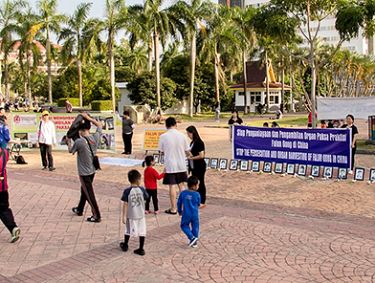 图2:法轮功学员展开横幅,揭露中共迫害