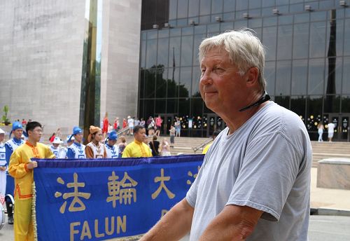 '图8:在华盛顿特区居住了四十四年的唐纳德·考特臣(Donald Cotchen)先生说:法轮功学员获邀参加美国首都独立日游行,印证了这个国家所崇尚的自由。他们在这里有炼功的自由。'