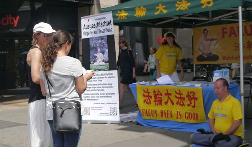 '图1:路人驻足了解更多法轮功真相'