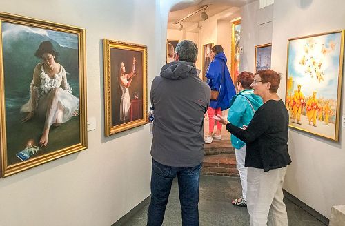 '图1~3:前来观看“真善忍美展”的民众正在在认真观画。'