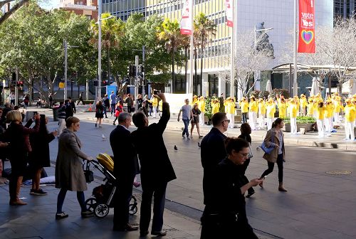 '图4:澳洲法轮功学员在著名旅游景点环形码头的大炼功吸引人们驻足观看和照相。'