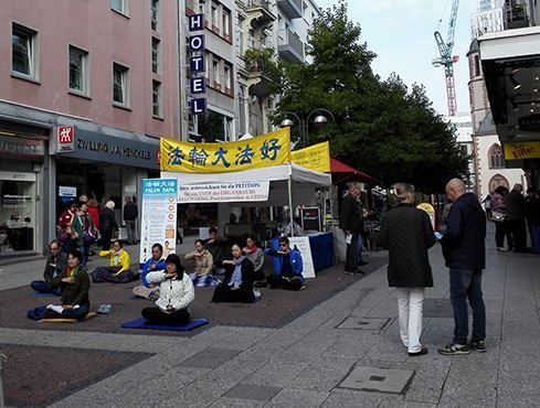 '图3:法轮功学员在展位上炼功'