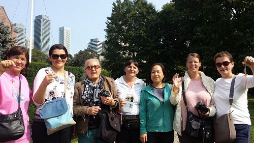 图5:来自南欧克罗地亚(Croatia)的一个旅游团,拿到了传单和法轮功学员给的小莲花,她们邀请了法轮功学员跟她们合影。