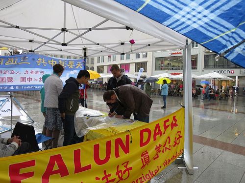 '图7:人们冒雨前来签名'